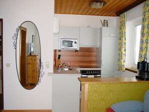 Eine kleine Küche mit Mikrowelle, Spüle und Holzschränken.