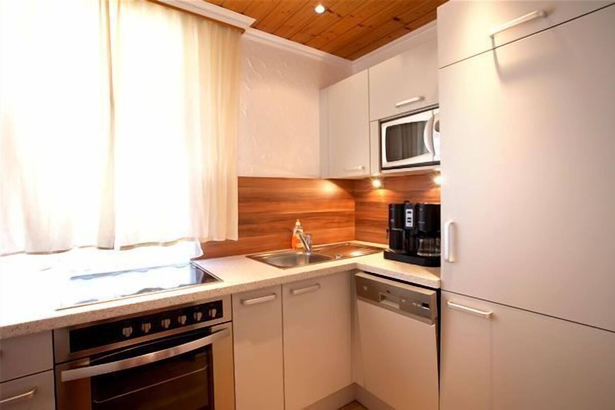 A compact kitchen with a microwave, coffee maker, and a dishwasher.
