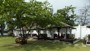 A garden with a gazebo, a small wooden structure, and a wheelbarrow. - Bearland Paradise Resort (Tigbauan)