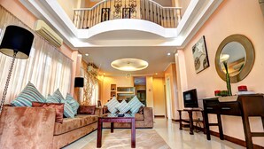 A spacious living area with a high ceiling, a balcony, and a modern interior design. - Bearland Paradise Resort (Tigbauan)