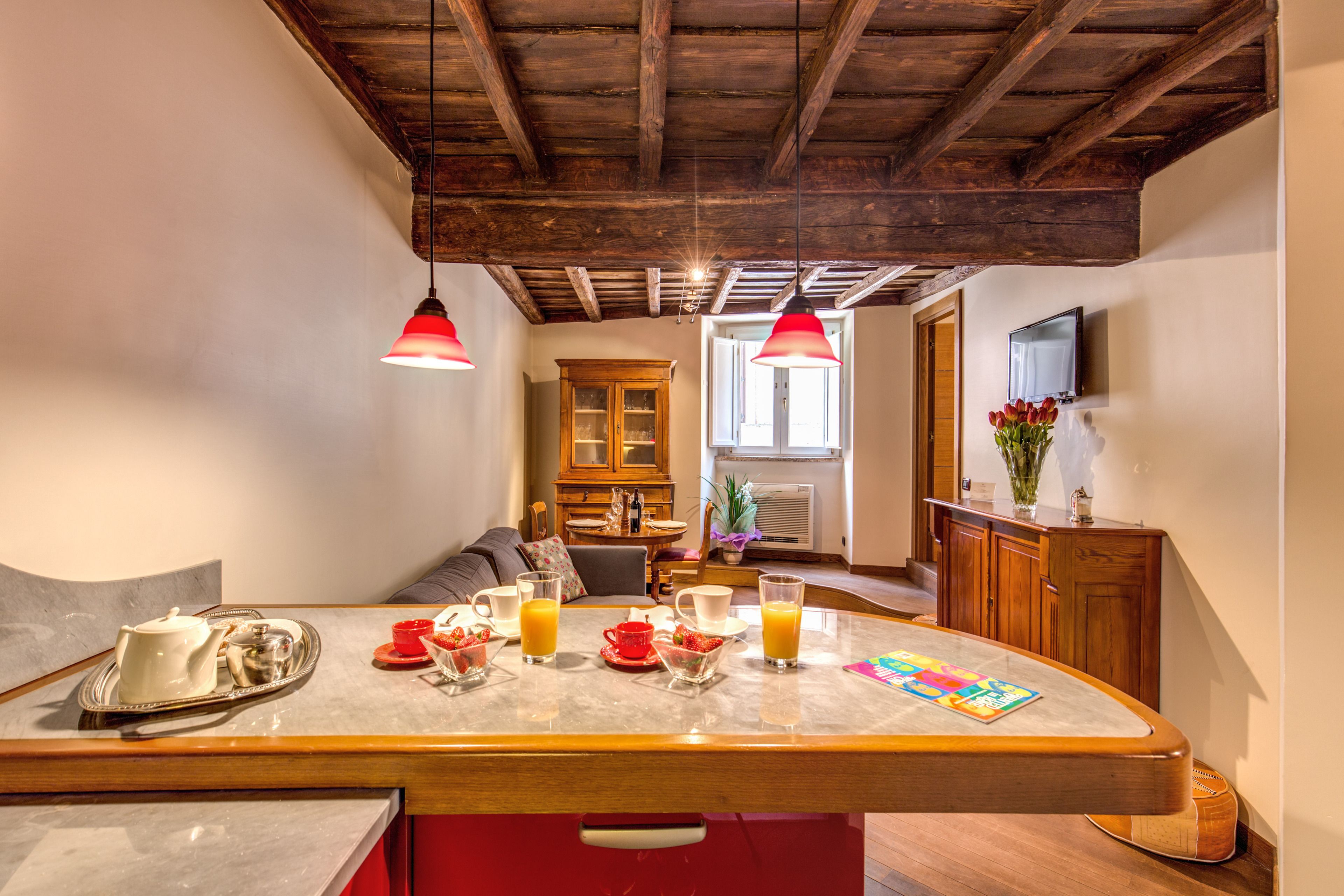 Eine Küche mit Marmorarbeitsplatte, Holzschränken und einem Essbereich mit einer Couch.
