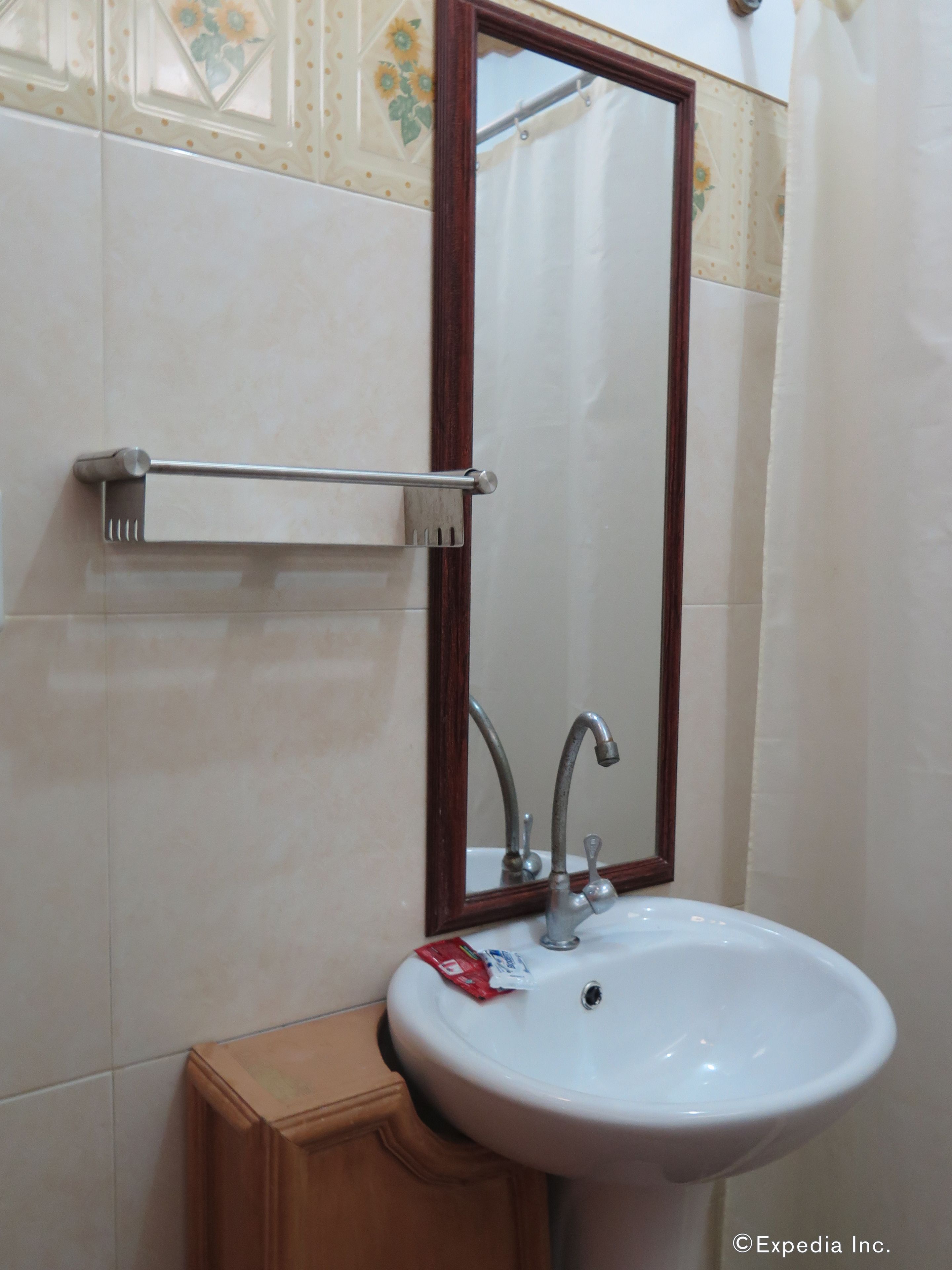 Un baño con un lavabo blanco, un mueble de madera y un perchero para toallas.