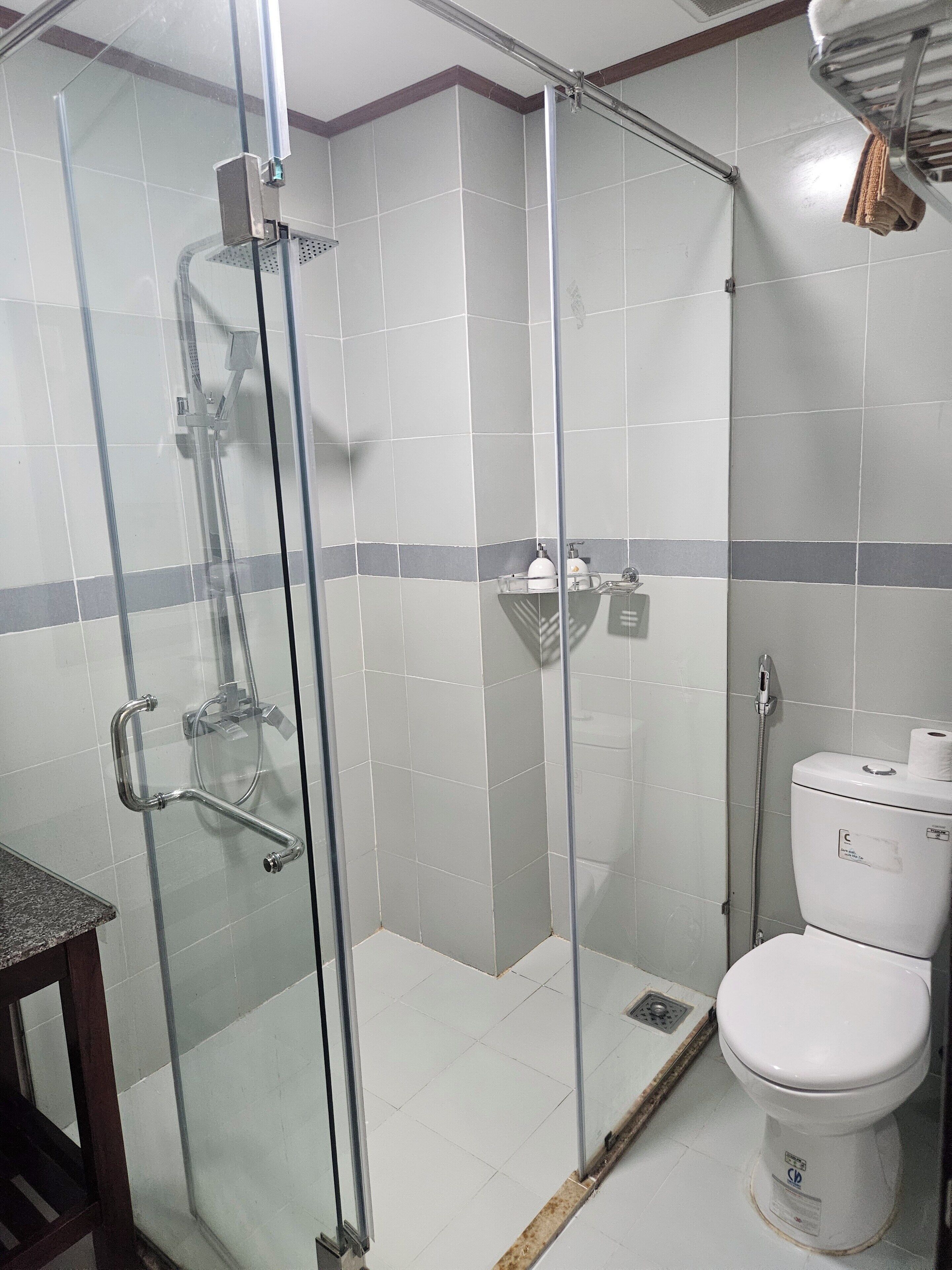 Une salle de bain avec une douche à parois de verre, des toilettes et un lavabo.