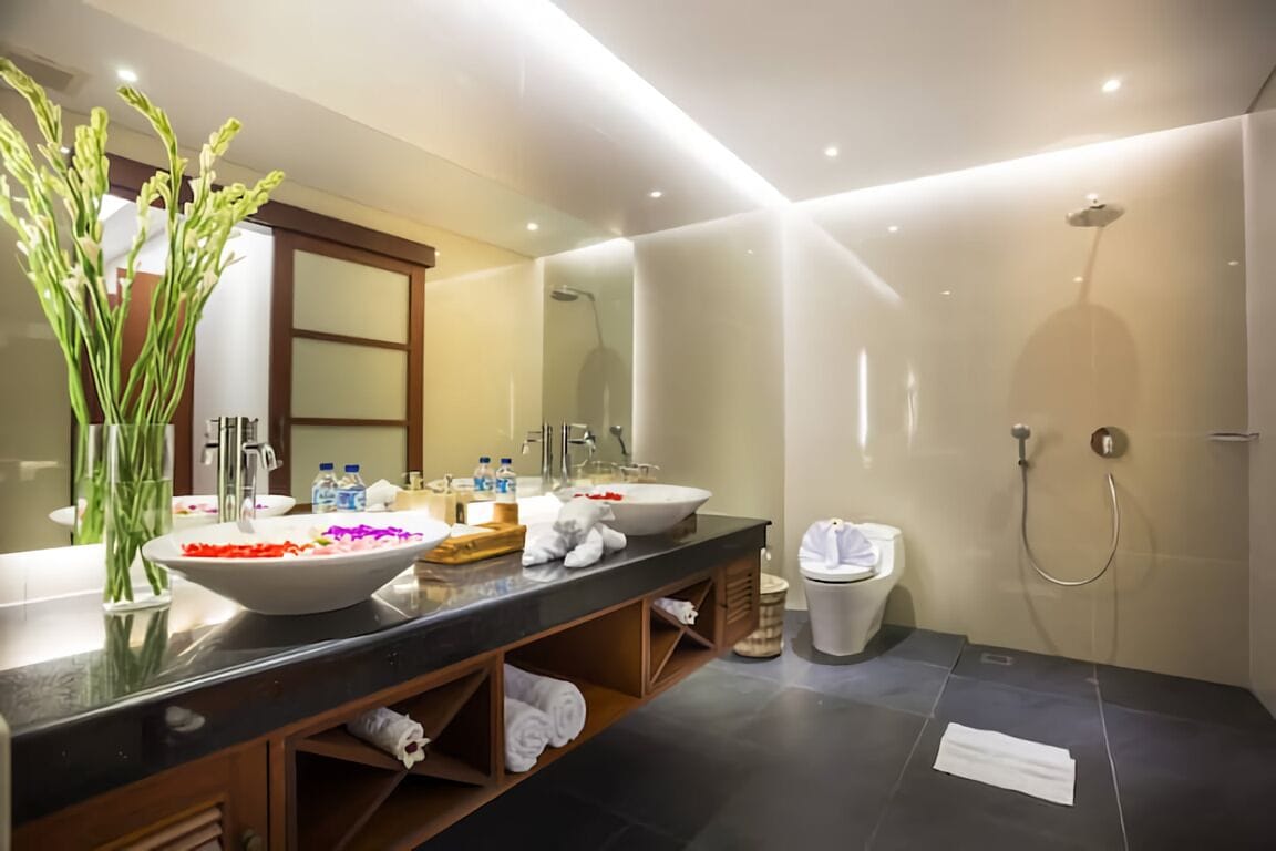 Un baño moderno con un lavabo grande, espejo y ducha.