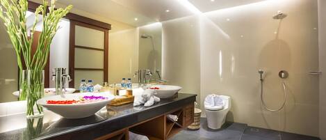 Un baño moderno con un lavabo grande, espejo y ducha.