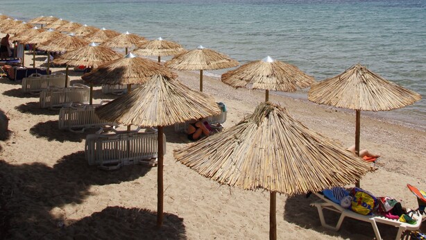 A beach with straw umbrellas and lounge chairs. - Porto Matina Hotel (Polygyros)