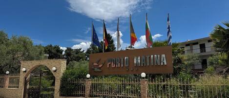 Un letrero con banderas y el nombre 'Puro Matina' frente a un edificio.