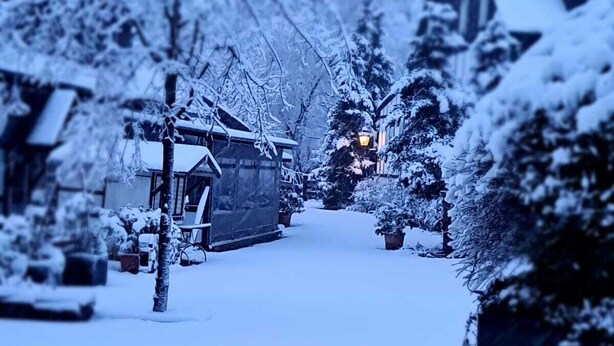 A snow-covered street with houses and a visible street lamp. - Hotel Gut Moschenhof (Düsseldorf)