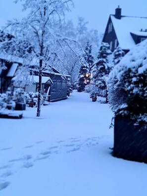 A snow-covered street with houses and a visible street lamp. - Hotel Gut Moschenhof (Düsseldorf)