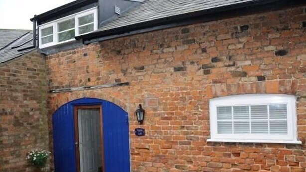 A stone building with a blue door and a window with white shutters. - Apple Loft (Alford)