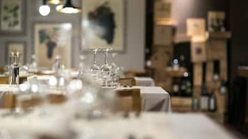 A restaurant with tables set for dining, glasses, and bottles on the tables.