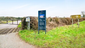 Señal direccional para Kirby Hall, un edificio histórico, con una señal de advertencia cerca.