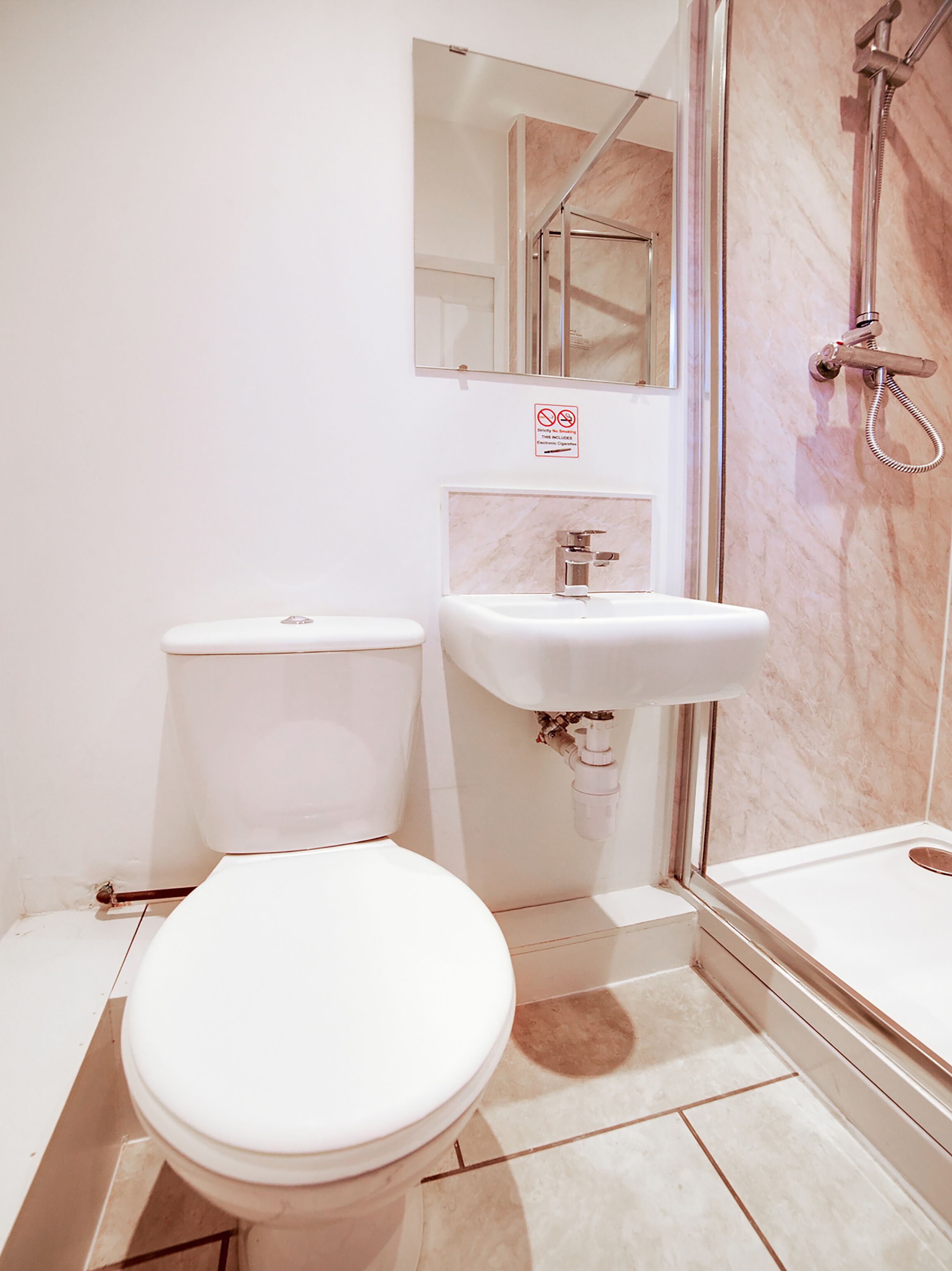 Un baño con inodoro, lavabo y ducha.