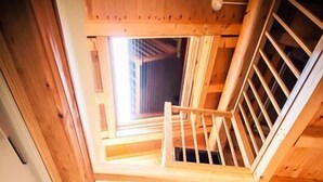 A wooden staircase leading to an upper floor with a view of the sky through a window. - Les Ecuries de la Tour (Mondonville)