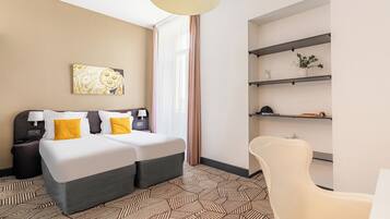 Una habitación de hotel con una cama, mesitas de noche, una silla, un escritorio y estantes con plantas.