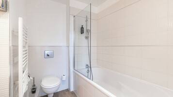 A bathroom with a toilet, a shower, and a bathtub.