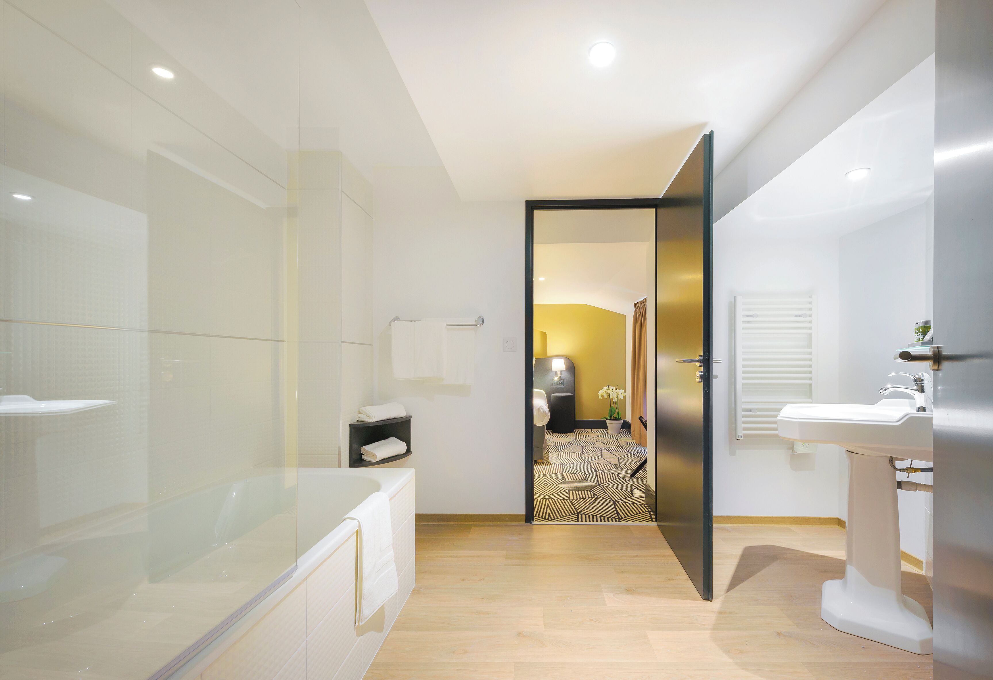 A modern bathroom with a glass shower enclosure, a bathtub, a toilet, and a sink.