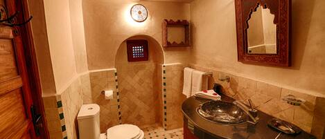 Un baño con inodoro, lavabo y espejo.