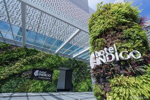 The exterior of the Hotel Indigo Singapore Katong, featuring a modern glass facade, lush vertical gardens, and a prominent sign. - Hotel Indigo Singapore Katong  by IHG (Singapore)