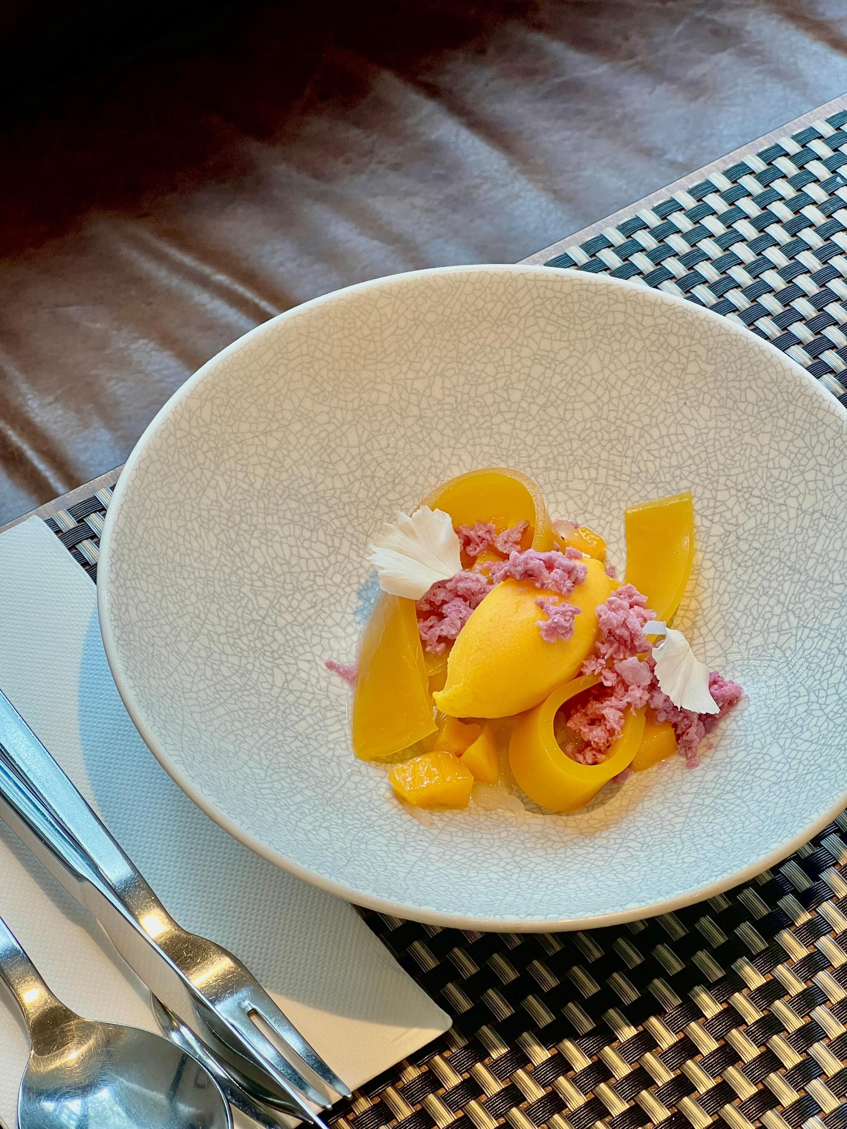 A bowl of food on a table with a woven placemat.