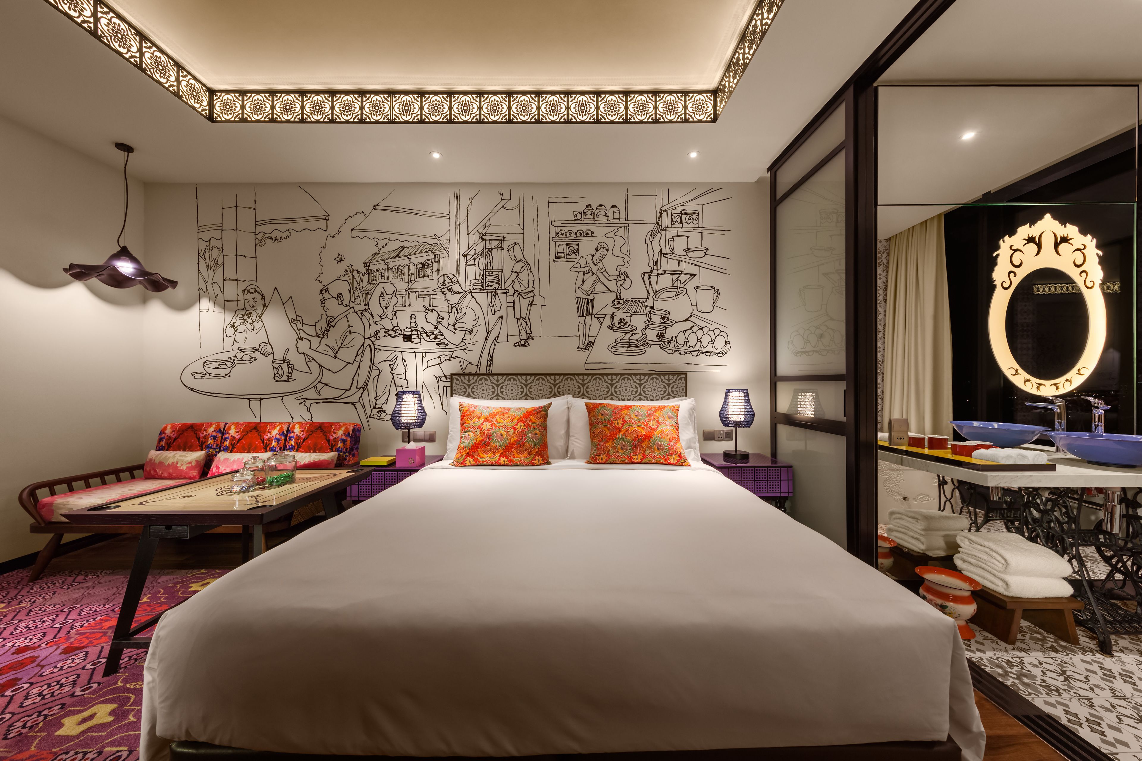 Una habitación de hotel moderna con una cama grande, un área de comedor y un baño con un espejo grande y lavamanos.