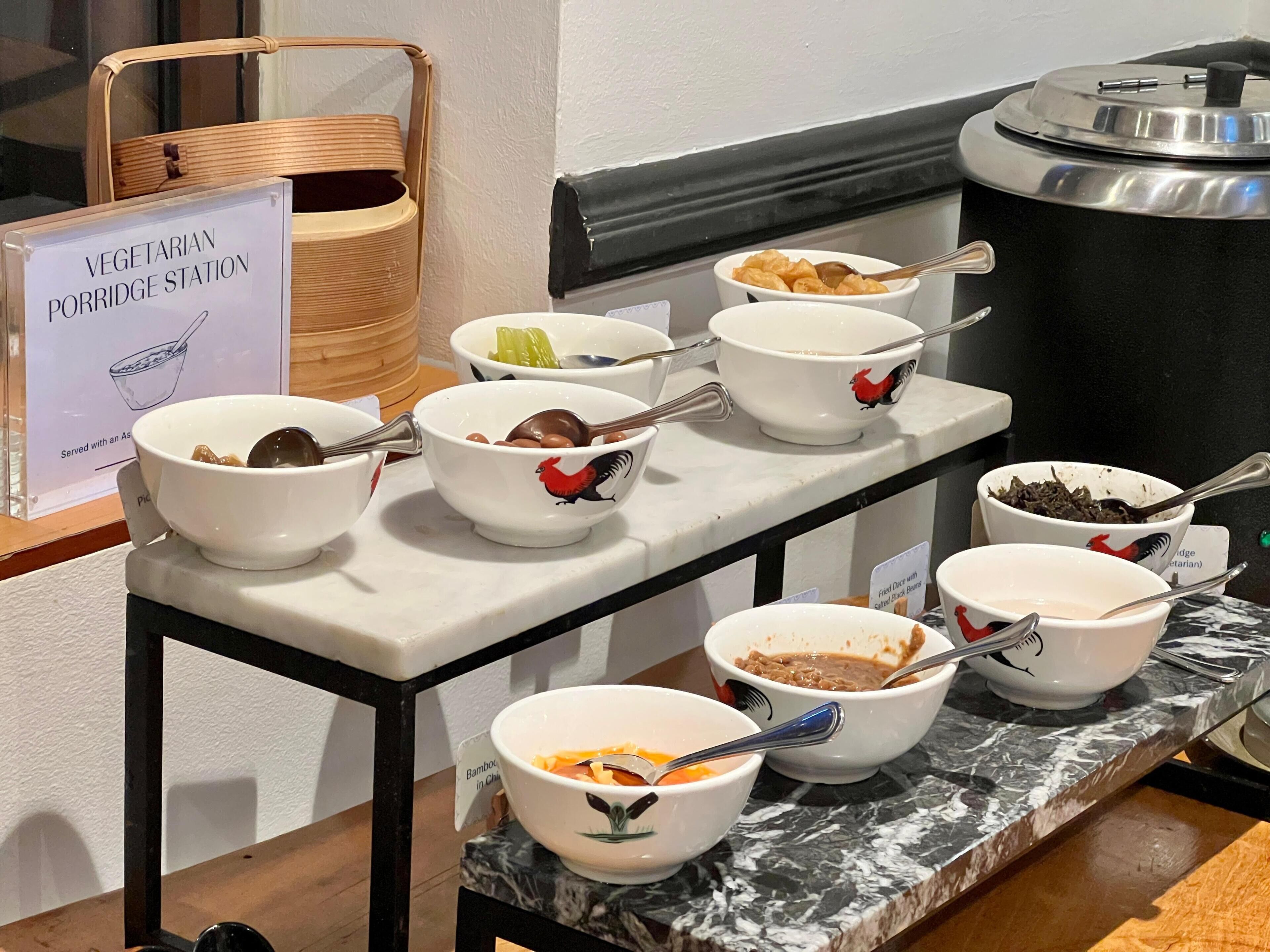 A buffet station with various bowls of food, including a sign indicating vegetarian options.