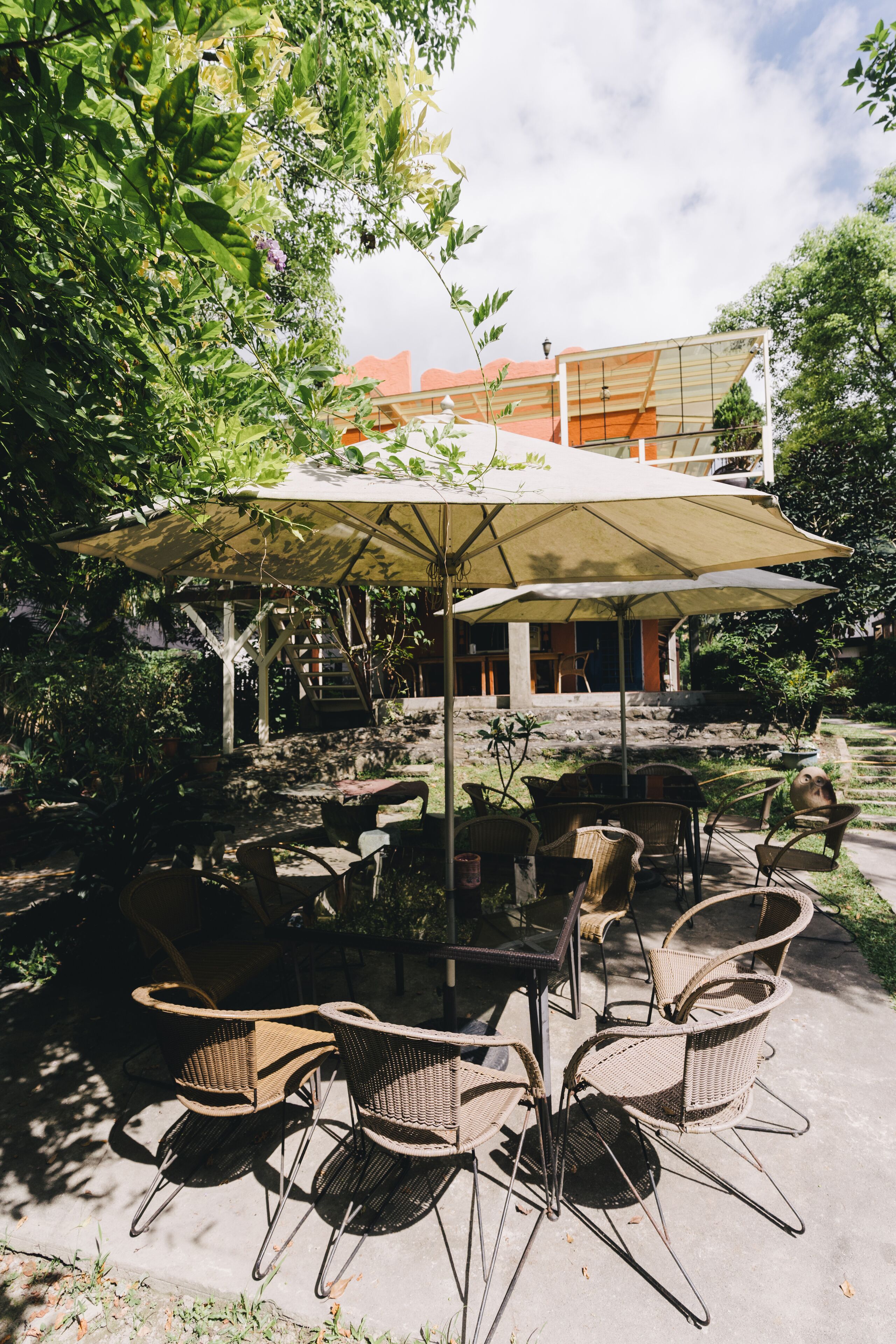 An outdoor seating area with wicker chairs and a large umbrella.