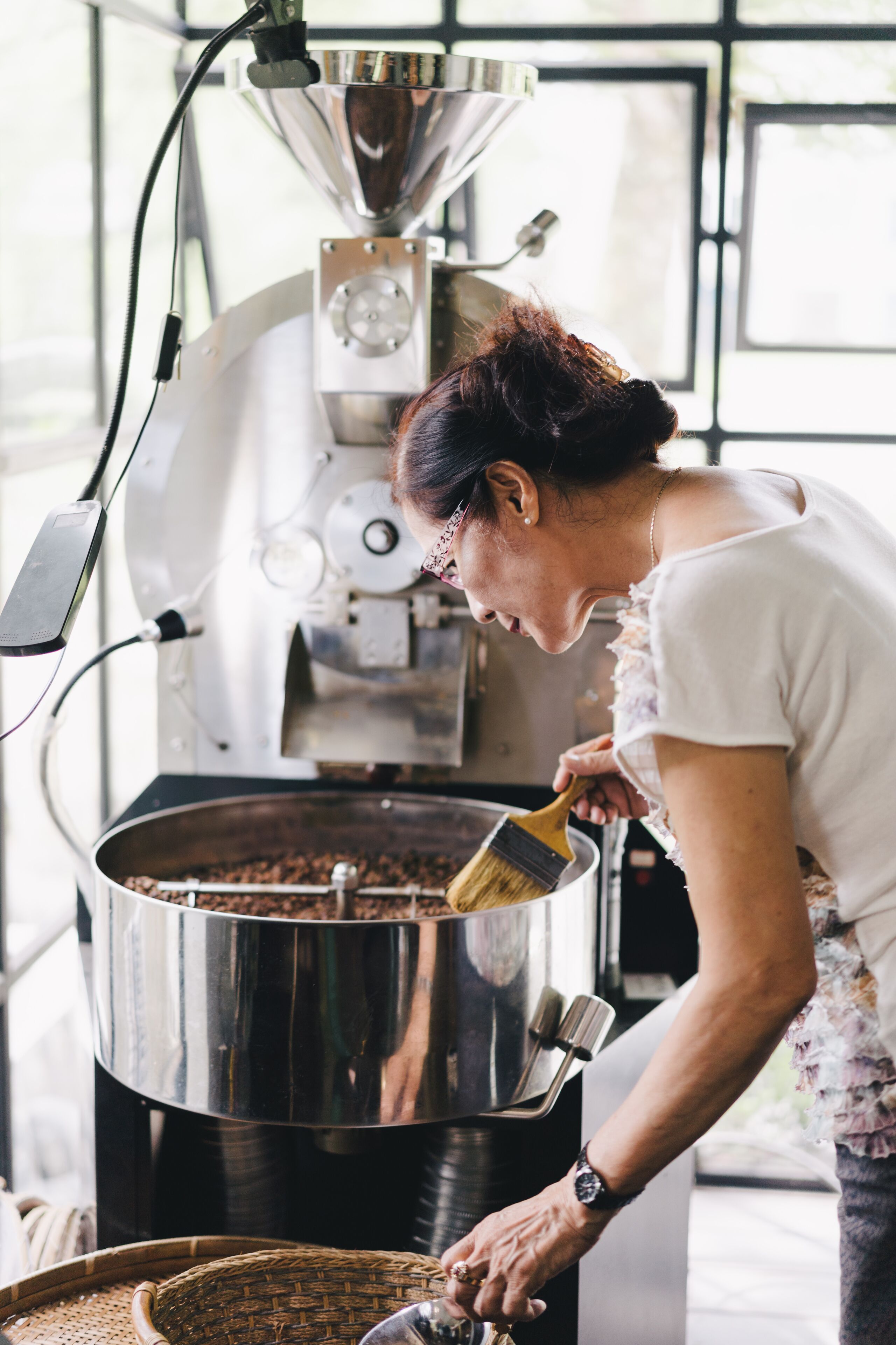 Una persona operando una máquina tostadora de café en una cocina.