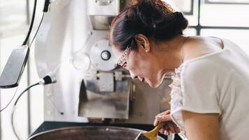 Una persona operando una máquina tostadora de café en una cocina.