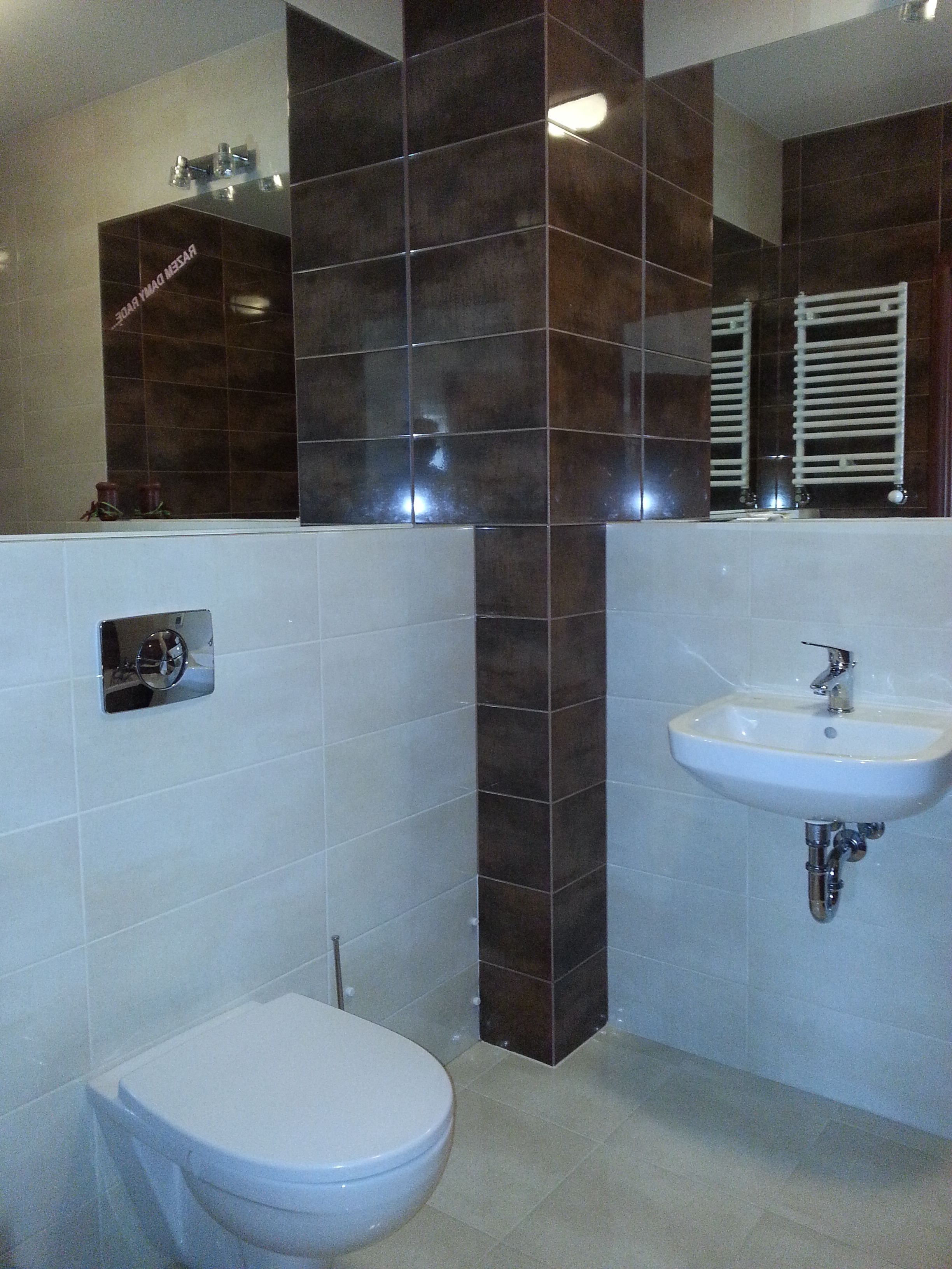 Un bagno con il water, un lavandino e uno specchio.