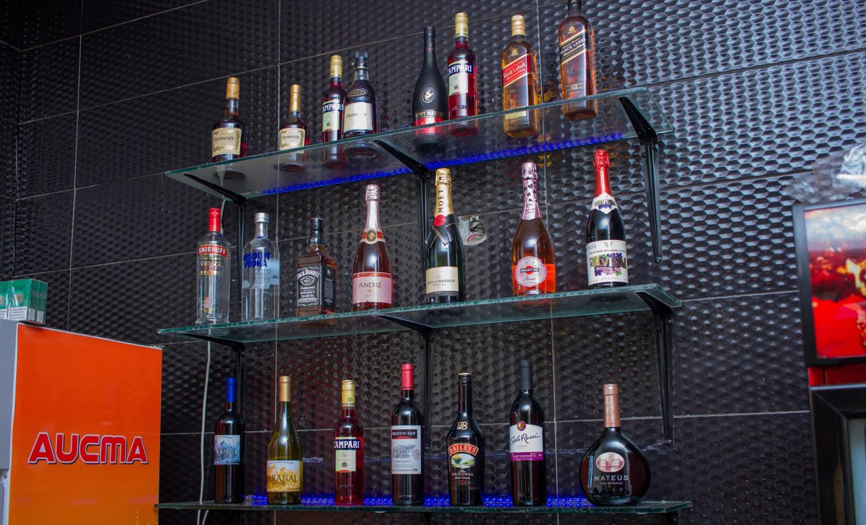 A bar with multiple shelves of liquor bottles.