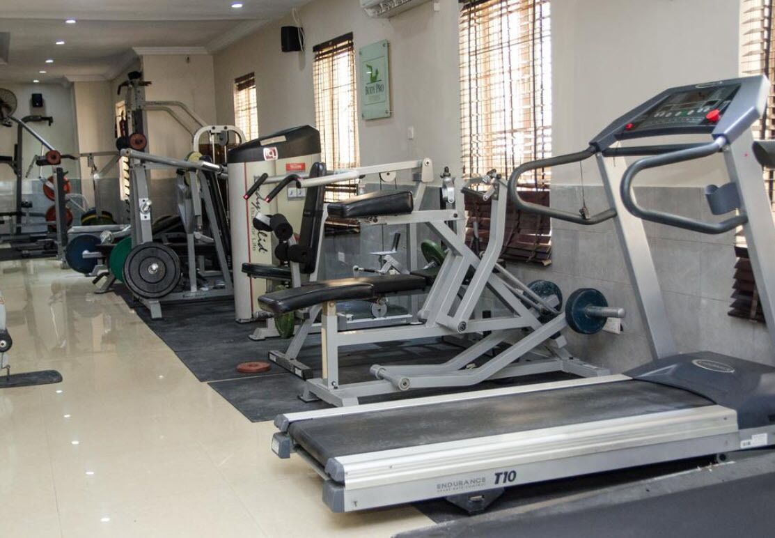 A gym with various exercise equipment including treadmills, weight machines, and free weights.