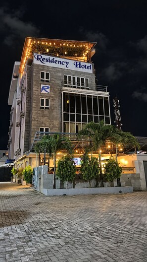 A building with a sign reading 'Residency Hotel' and a parking symbol.