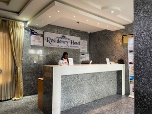 A reception desk at a hotel with a marble wall and a sign that reads 'Residency Hotel.' - Residency Hotel Lekki Lagos (Lekki)