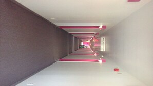 A long, narrow hallway with a mirrored ceiling and pink accents. - Motel Econo-Nuit (Sherbrooke)