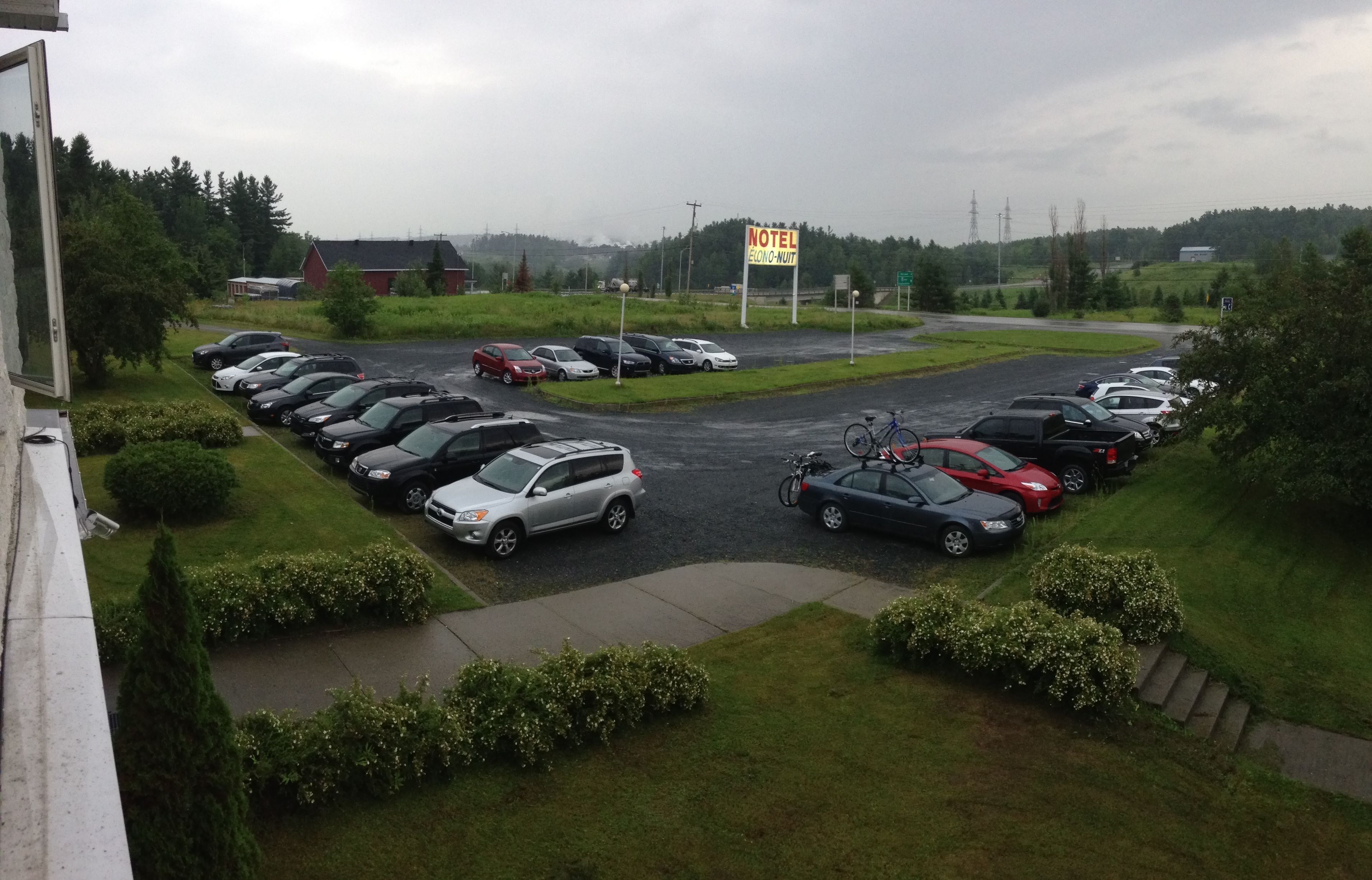 A parking lot with multiple cars and a sign for the Elong C-Nut Motel.