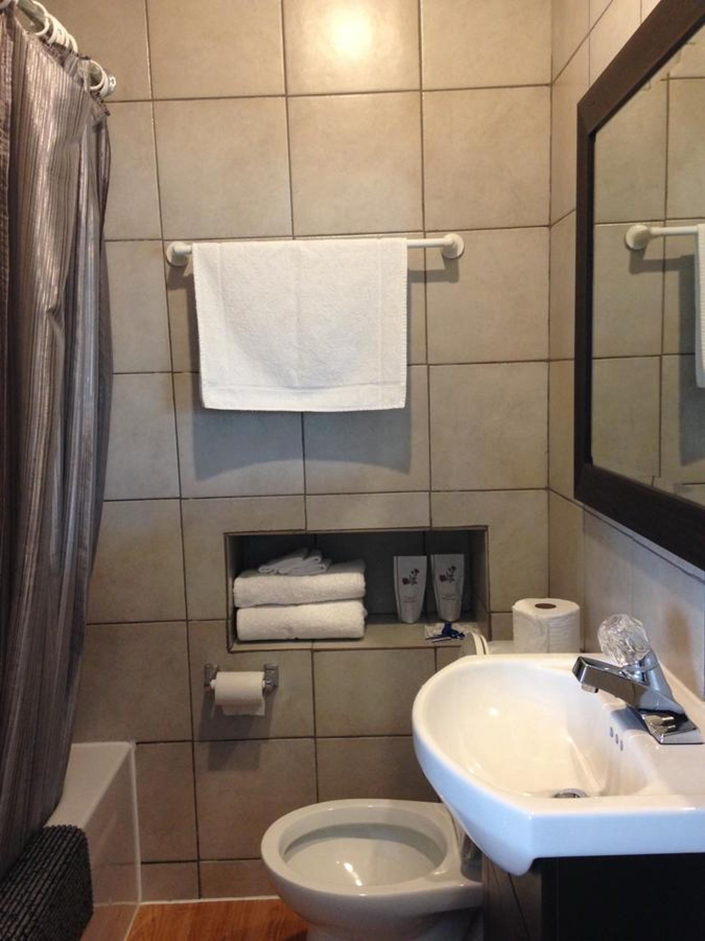 Ein modernes Badezimmer mit Toilette, Waschbecken und Handtuchhalter.