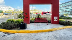 Entrada de un edificio rojo con un banco y una jardinera.