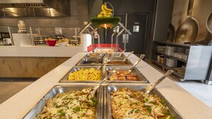 A buffet with various food options in metal containers. - ibis Queretaro (Querétaro)