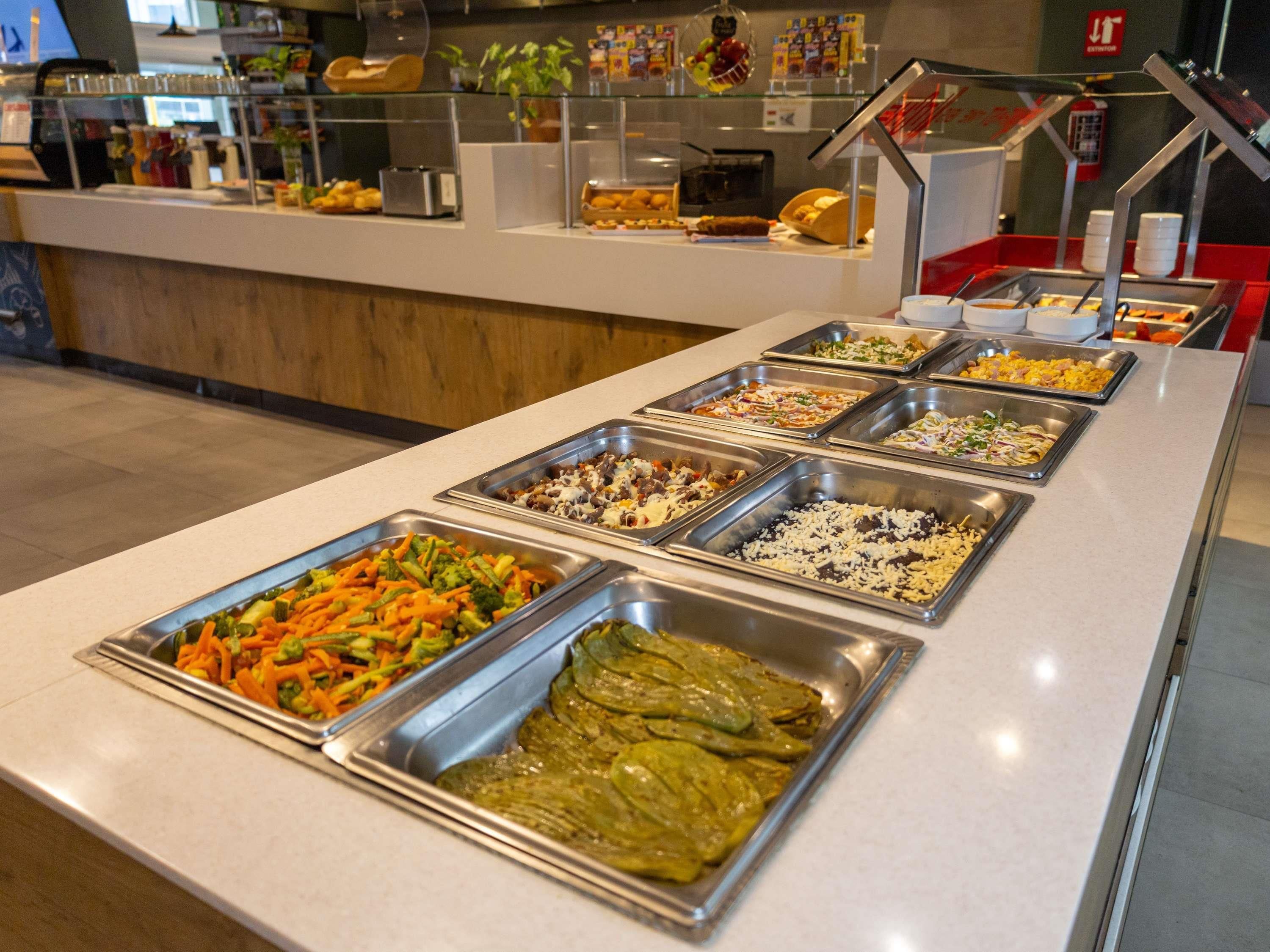 Un bufé con diversas opciones de comida, incluyendo ensaladas, carnes y otros platos.