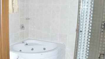 A bathroom with a bathtub, a shower, and a toilet.