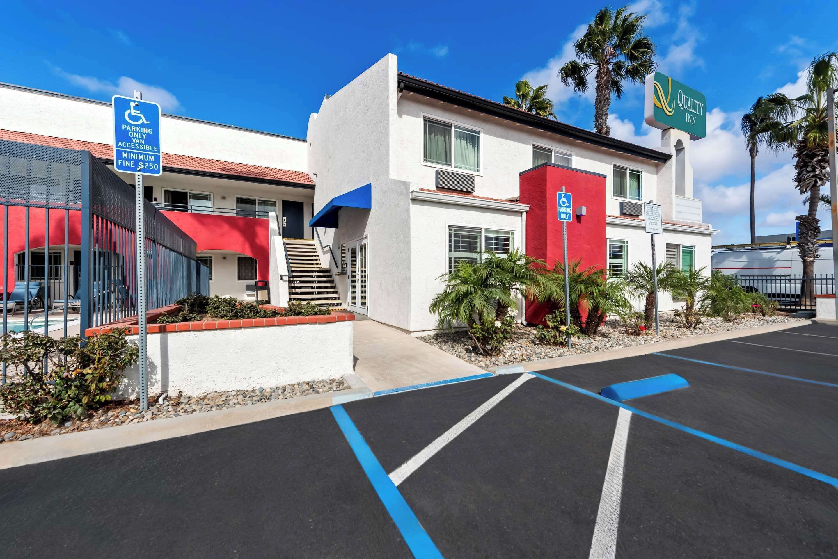 A hotel with accessible parking, a red awning, and a sign for a Quality Inn.