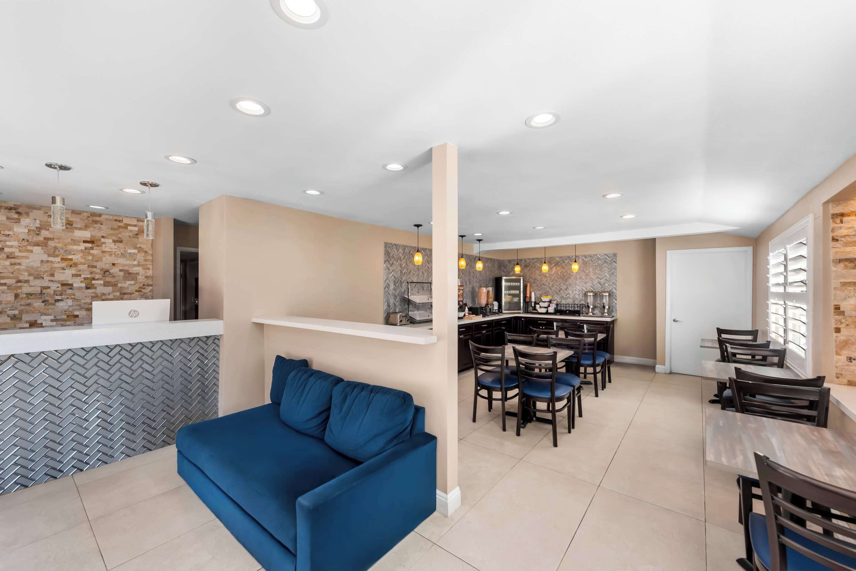A modern kitchen with a herringbone tile backsplash, a central island, and pendant lighting.