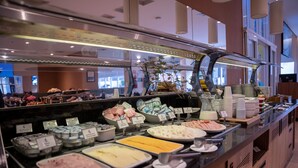A buffet counter with various food items and containers. - Comfort Hotel Santos (Santos)