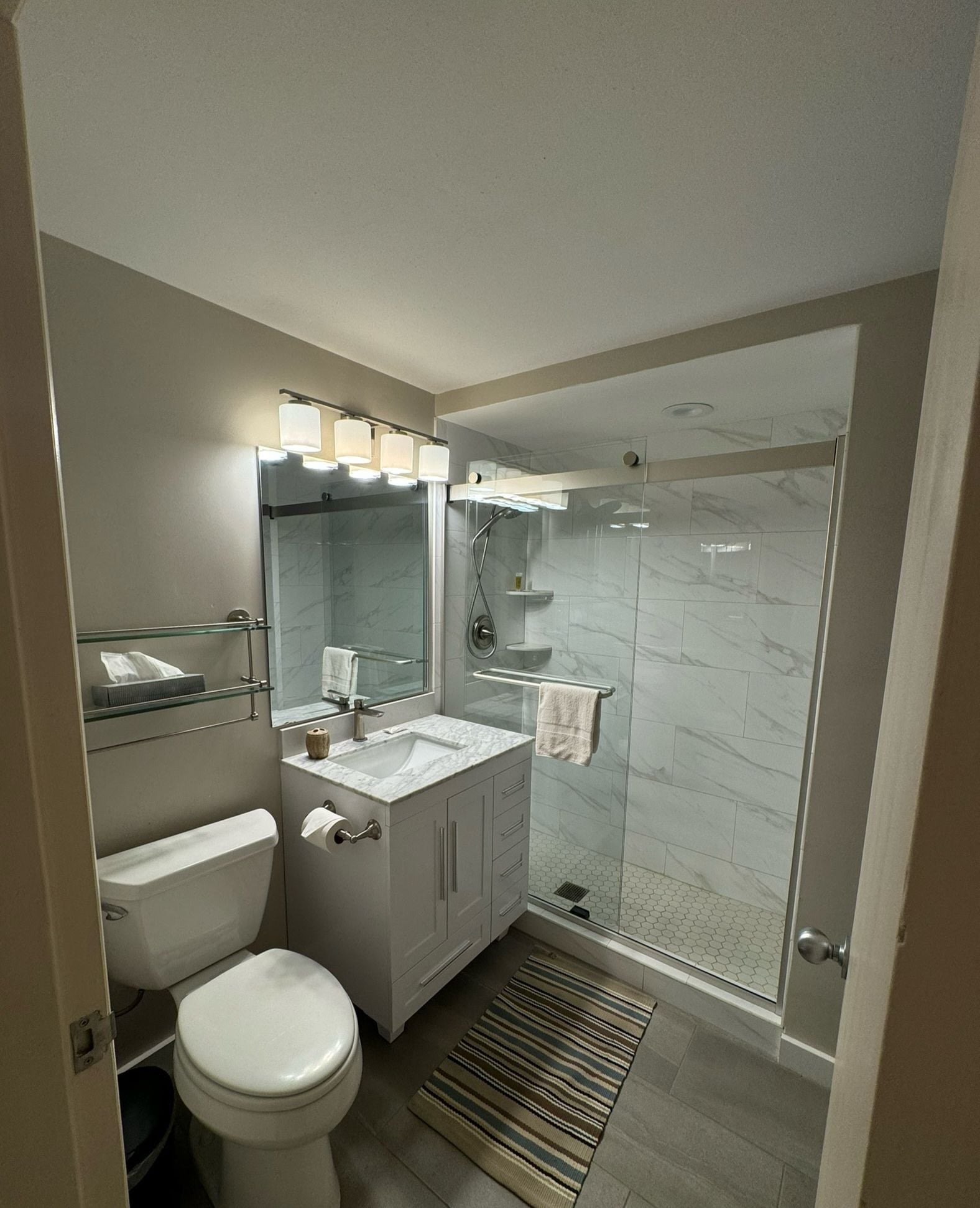 A modern bathroom with a toilet, sink, and shower.