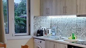 Una cucina moderna con un tavolo in marmo, sedie in legno, una lavatrice e un forno integrato.