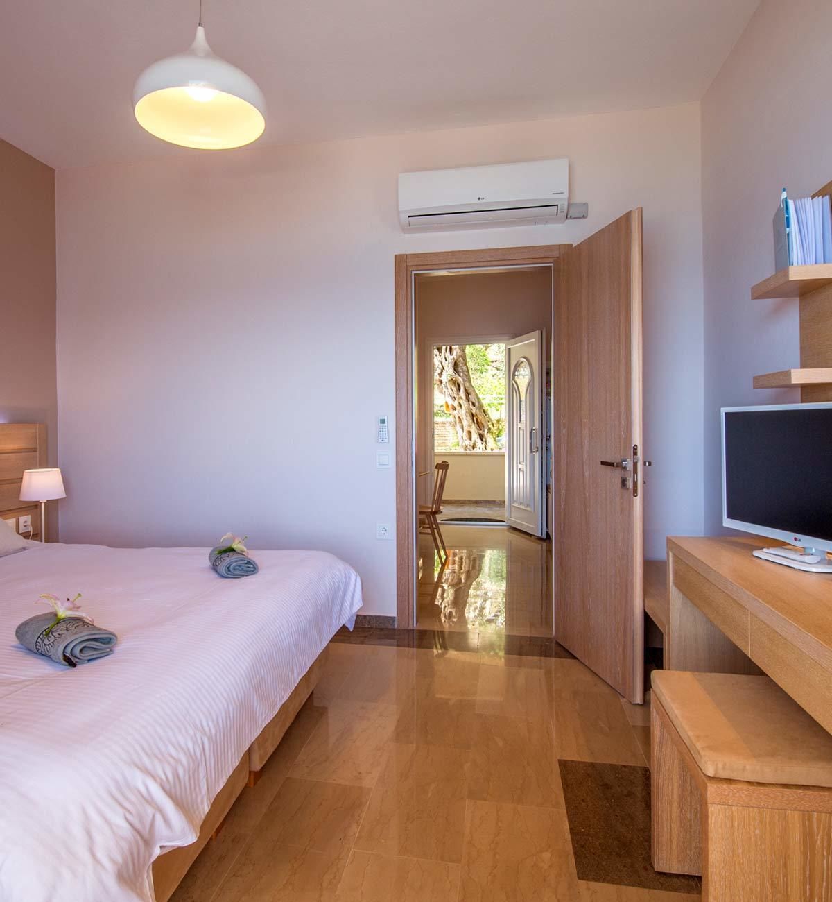 Ein Hotelzimmer mit Bett, Schreibtisch, Fernseher und Klimaanlage.
