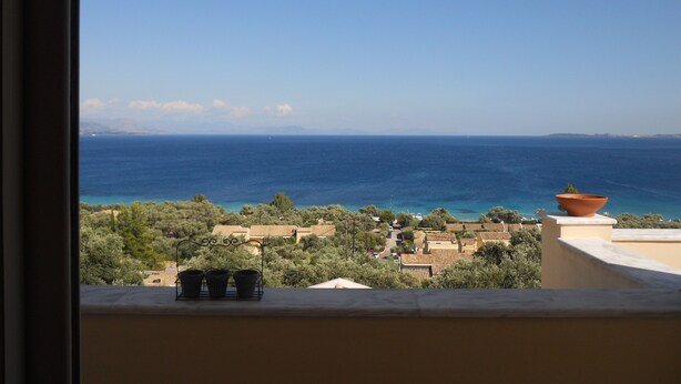 A balcony with a view of the sea and a village. - Barbati Beach Apartments (Corfu)