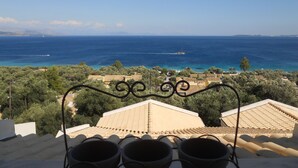 A terrace with a view of the sea, featuring a railing and a row of cups. - Barbati Beach Apartments (Corfu)