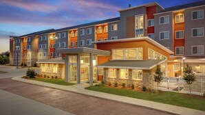 A multi-story residential building with a modern design, featuring a mix of balconies and large windows.